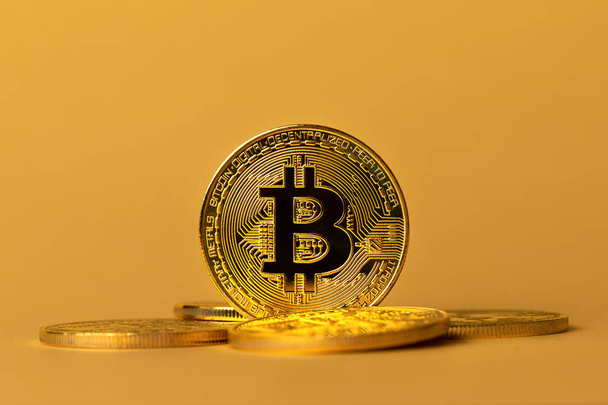 Closeup of gold bitcoins on yellow backgound - Photo, image