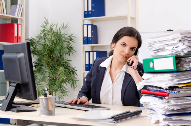 Impiegata donna con troppo lavoro in ufficio
  - Foto, immagini