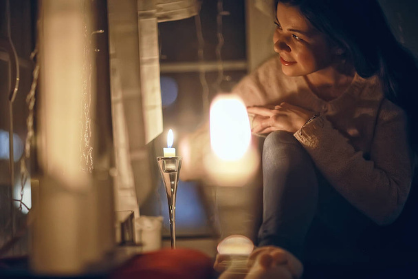 Christmas evening girl / beautiful young adult model, dreams and makes wishes at the candles in the New Year's Eve - Zdjęcie, obraz