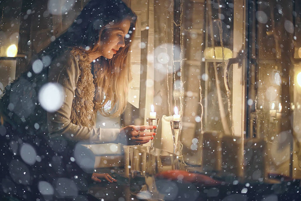 Christmas evening girl / beautiful young adult model, dreams and makes wishes at the candles in the New Year's Eve - Foto, Imagen