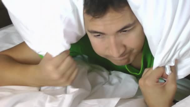 Hombre tratando de dormir con una almohada sobre su cabeza
 - Metraje, vídeo