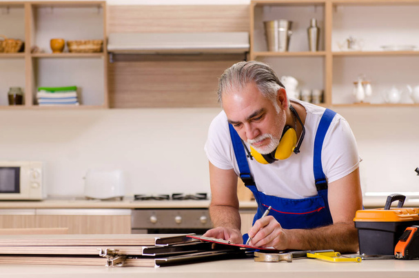 Пожилой подрядчик ремонтник, работающий на кухне
  - Фото, изображение