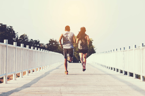 young couple runner running on running road in city park - Fotó, kép