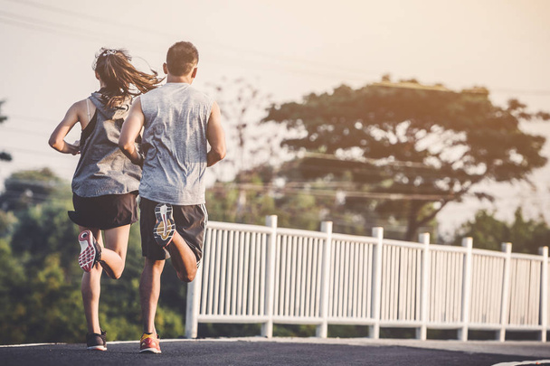young couple runner running on running road in city park - 写真・画像