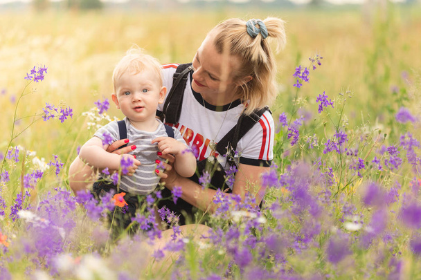 Mother and child playing in the field with flowers. - Fotografie, Obrázek