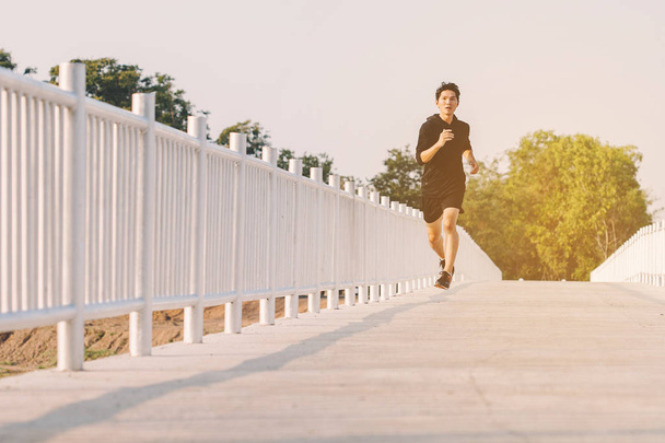 young man runner running on running road in city park - 写真・画像