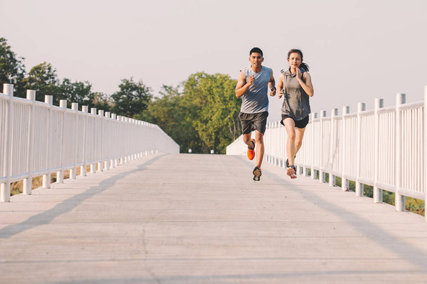 young couple runner running on running road in city park - Fotó, kép