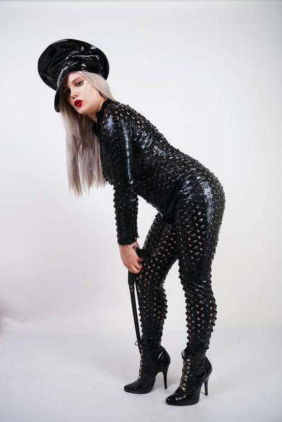 жестокий модный bdsm леди с кривыми одеты в черный комбинезон с сексуальными отверстиями и позируя на белом фоне в студии
 - Фото, изображение