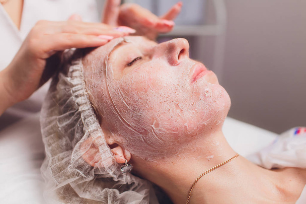 Beautiful young woman having a facial cosmetic mask at spa salon. Girl is having cosmetic treatment. - Valokuva, kuva