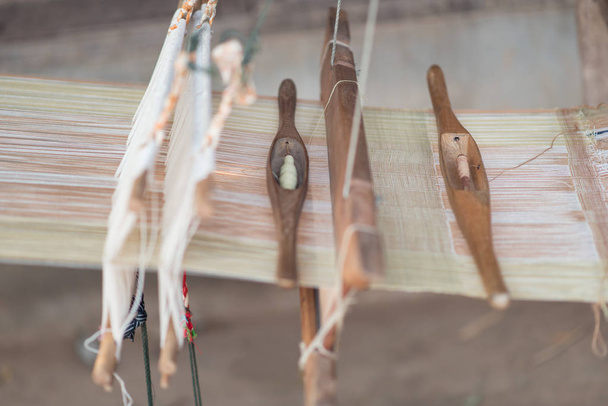 Outil de tissage de navette sur le métier à tisser antique et le fil, traditionnel
 - Photo, image
