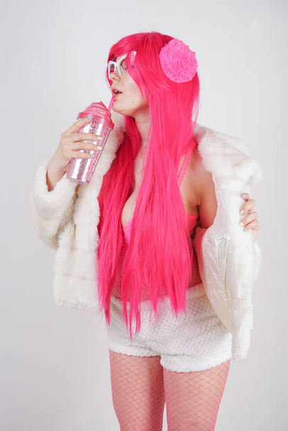 sexy paffuto donna dai capelli rosa indossa lingerie sexy e giacca di pelliccia con occhiali da sole in plastica su sfondo bianco studio da solo
 - Foto, immagini