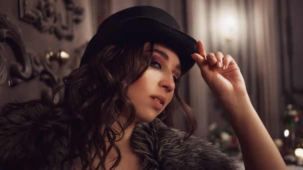 Mooie jonge brunette vrouw in Top Hat, mysterieuze interieur - Foto, afbeelding