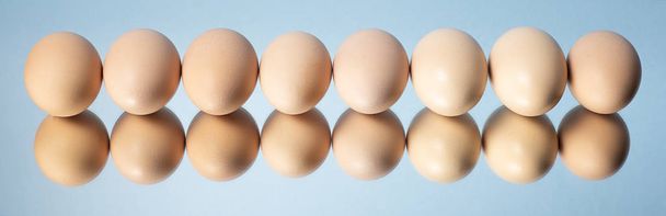 Ruskeat munat asetettu pitkään riviin peiliin sinisellä pohjalla
 - Valokuva, kuva