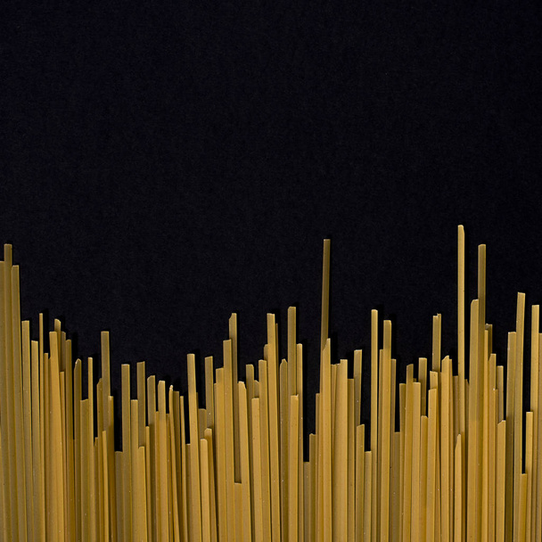 Raw ploché špagety na černém pozadí - Fotografie, Obrázek