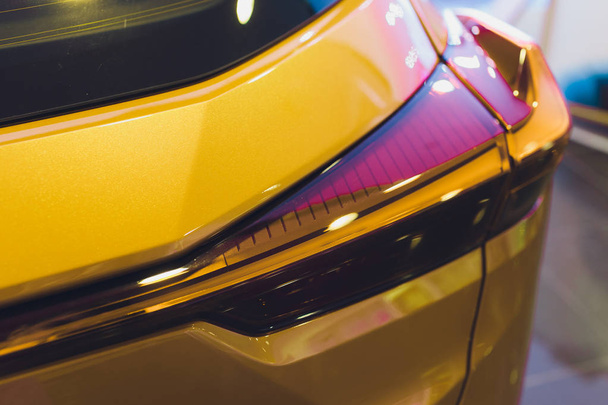 Detail on the rear light of a pink car. yellow - Foto, Imagen