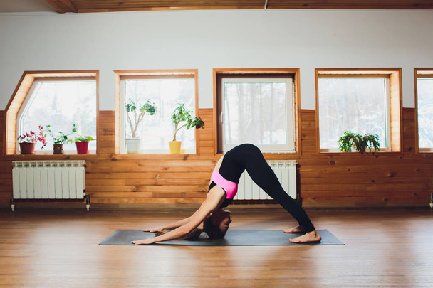 Fitness woman practices yoga asana parvatasana yoga studio interior. - Φωτογραφία, εικόνα