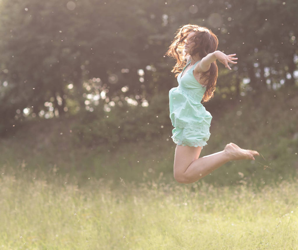 leap in the sky.enthusiastic young woman enjoying freedom - Foto, afbeelding