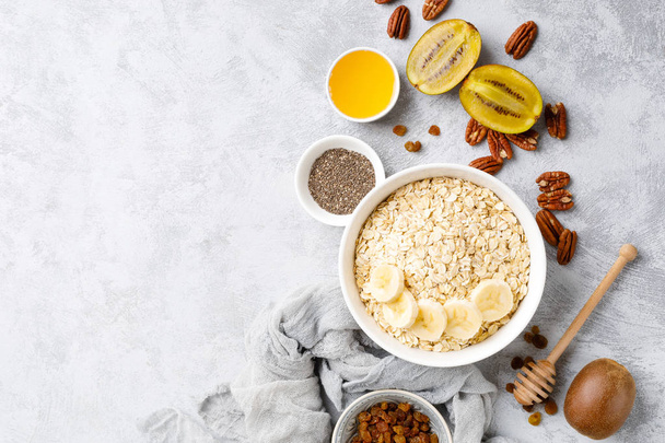 Oat flakes with fruits, nuts and honey in bowl - Foto, imagen