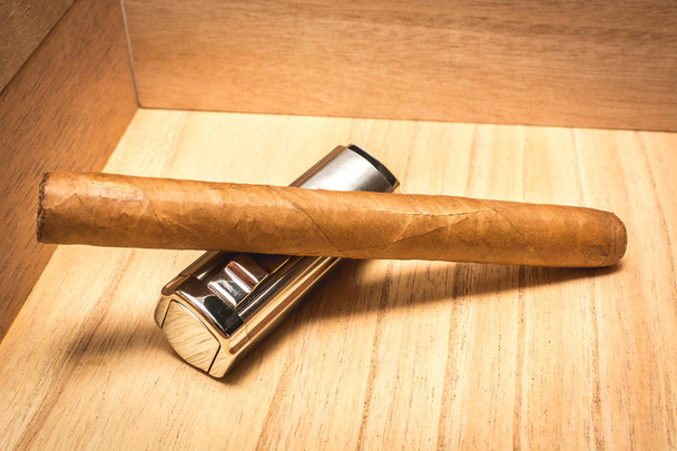 A nice Cuban cigar and a lighter in Spanish humidor. - Zdjęcie, obraz