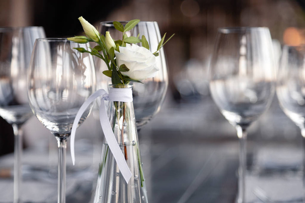 Modern restaurant setting, glass vase with bouquet flowers on ta - Foto, afbeelding