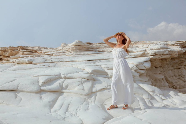 Charming young woman wearing sundress posing on white cliff near sea, Cyprus. - Fotó, kép
