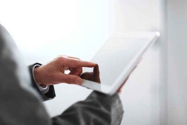 close up.blurred image businessman presses on the screen of a digital tablet.photo with copy space - Photo, Image