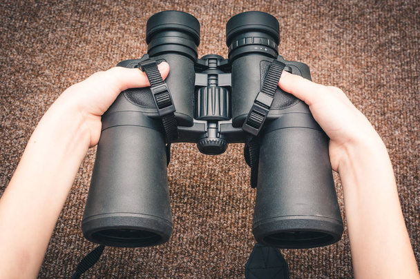 Hands holding binoculars, close up view - Foto, Imagen