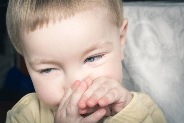 Beautiful baby pinches your nose and mouth with hands - 写真・画像