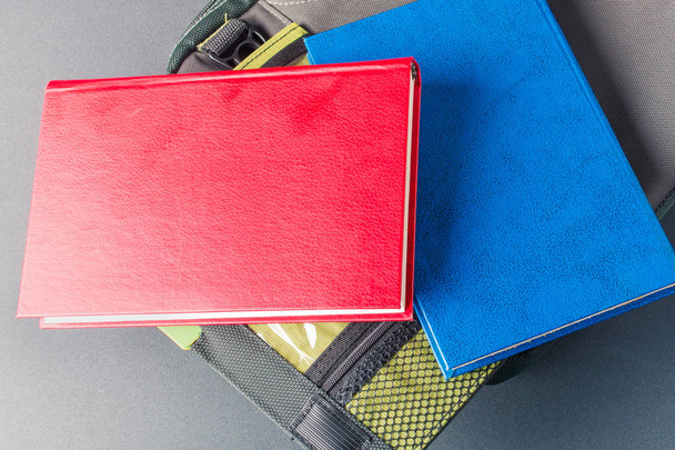 Libro rosso e blu si trova su una borsa per computer portatile
 - Foto, immagini