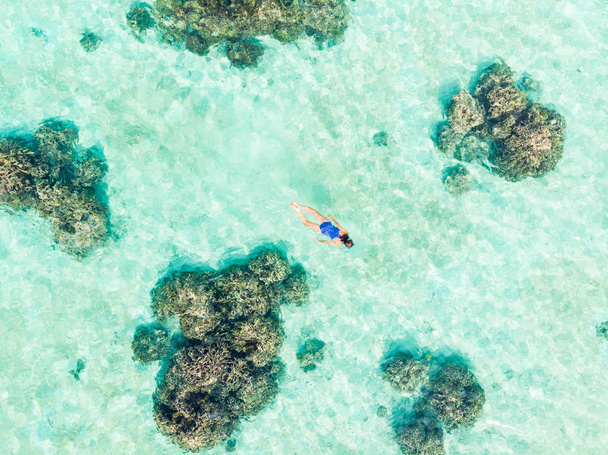 サンゴ礁熱帯カリブ海、ターコイズブルーの水でシュノーケリングの空中トップダウンの人々。インドネシアワカトビ諸島、海洋国立公園、観光ダイビング旅行先 - 写真・画像