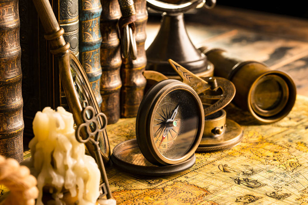 Antique compass on the background of a candle with a key and boo - Fotó, kép