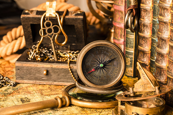 Antique compass on the background of a treasure chest with gold  - Valokuva, kuva