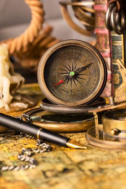 Antique compass on the background of a candle and books. Vintage - Φωτογραφία, εικόνα