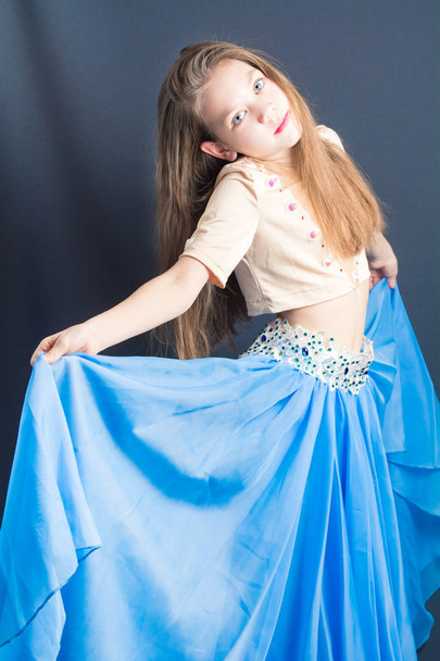 Gyönyörű lány egy kék ruhában végez keleti táncok - Fotó, kép