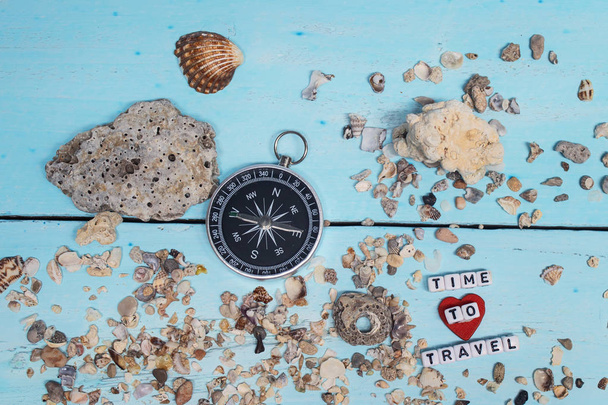 Time to Travel. Idea for tourism with compass on the sand with corals on the wooden background. - Foto, Bild