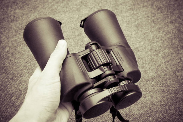 Hands holding binoculars, close up view - Foto, afbeelding
