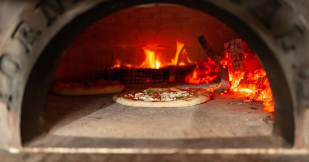 Pizza margherita in a wood oven. - Photo, Image