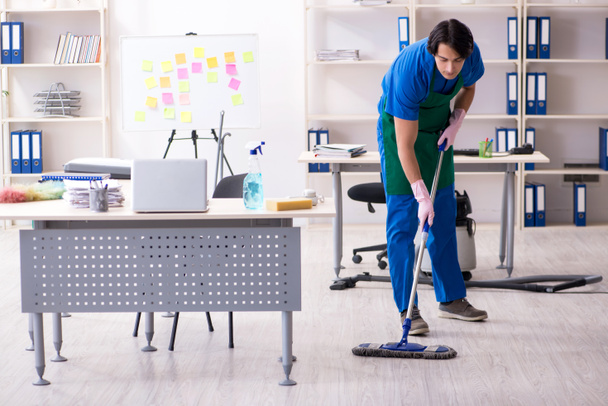 mężczyzna przystojny profesjonalny sprzątaczka pracuje w biuro  - Zdjęcie, obraz