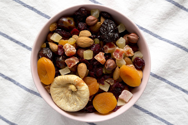 Dried fruits and nuts in a pink bowl, top view. Overhead, flat l - Photo, Image