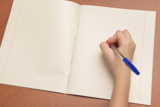 The hand of a schoolgirl writes a pen in notebook. - 写真・画像