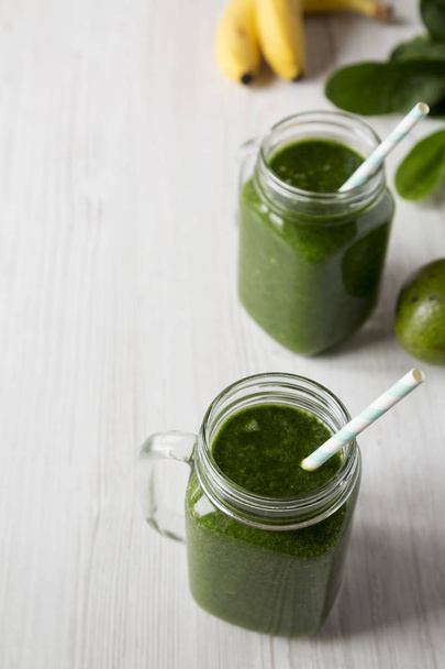 Green smoothie with spinach, avocado and banana in glass jars, l - Fotó, kép