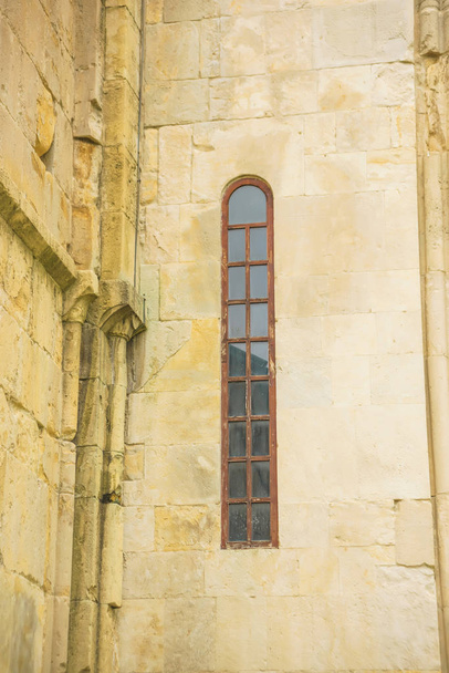 weißer Altbau. historische Architektur von Georgien. schmale hohe Fenster im Gebäude. die Textur von alten Steinmauern. - Foto, Bild