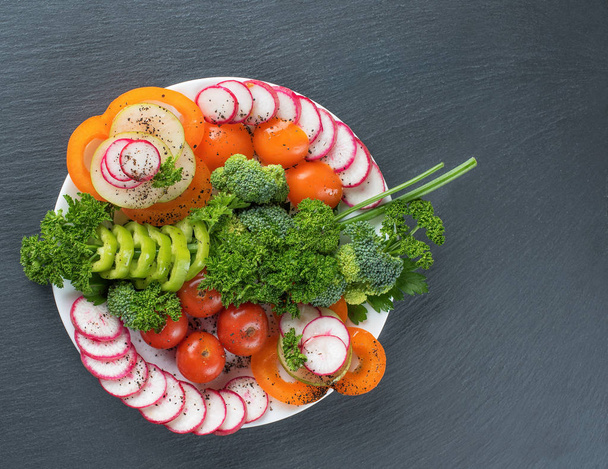 Vegetable salad on a plate on a gray background - Fotó, kép