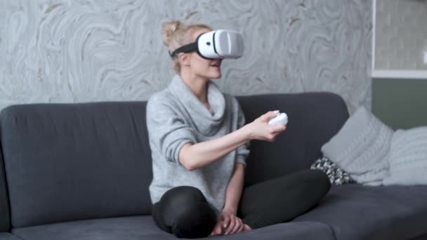 Young woman watching videos or playing with VR glasses on head - Video, Çekim