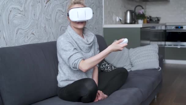 Young woman watching videos or playing with VR glasses on head - Záběry, video