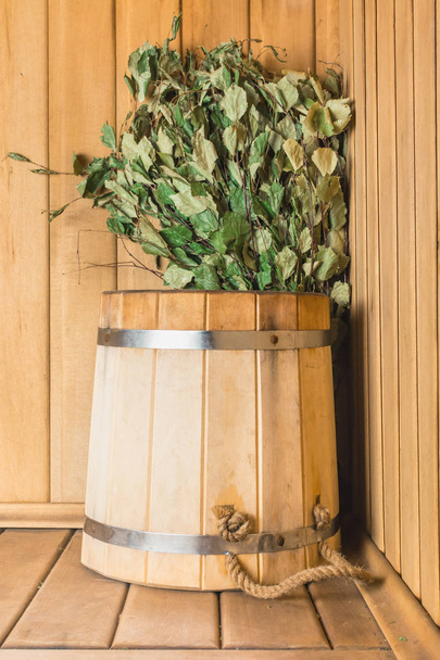 Wooden pail with birch broom in the sauna - Фото, зображення