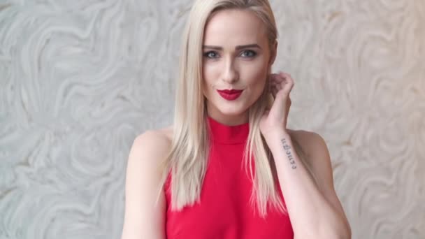 stilvolle elegante blonde Frau im heimischen Wohnzimmer, trägt rotes sexy Kleid - Filmmaterial, Video