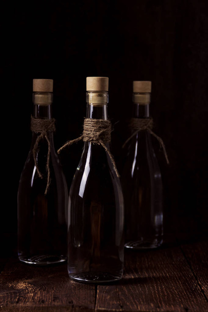 Bebidas espirituosas ou vodka de trigo em copo de vidro com grãos e espigas de trigo
 - Foto, Imagem