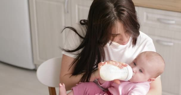 Frau füttert Neugeborenes mit Formel in Flasche - Filmmaterial, Video