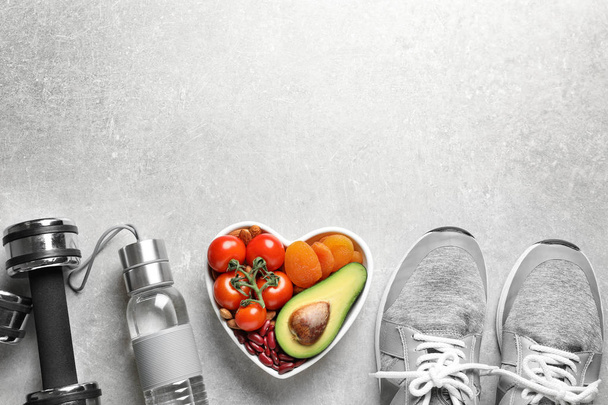 Heart-healthy products and sports equipment on grey background, flat lay. Space for text - Foto, afbeelding